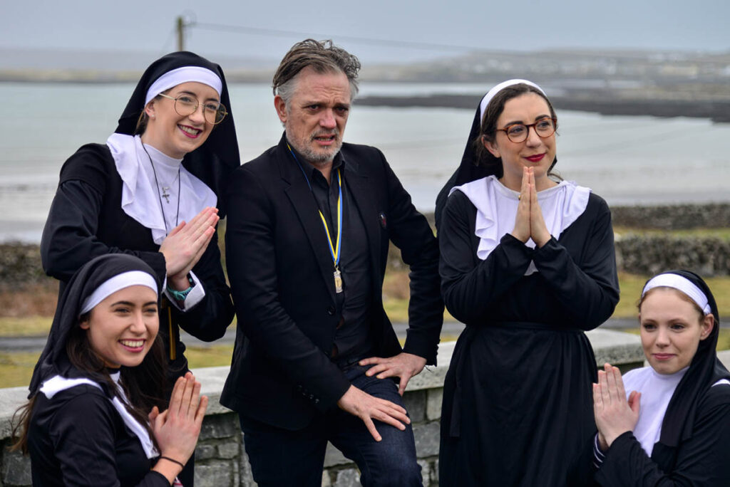 Joe Rooney AKA Fr Damo pictured with Sr Kate Finnegan, Sr Jessie Ryan, Sr Hayley Maher and Sr Eimear O Dea at TedFest as Inis Mór, Aran Islands becomes the legendary ‘Craggy Island’ for a weekend of high-jinx every year. TedFest is back on March 2nd-5th 2023 with copious cups of tea and sandwiches, a lot of red tank-tops, nuns on the run, priests on the pull, map-cap costumes and of course a bishop getting a kick up the arse. Fr Ted, Ireland’s best loved TV Show is celebrated in the most wild and wonderful way. see www.tedfest.org  Photo by Doris Gerth